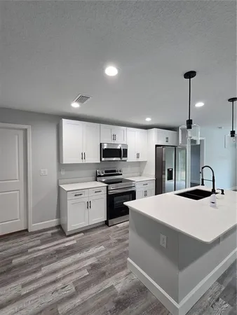 a large kitchen with kitchen island a sink stainless steel appliances and cabinets