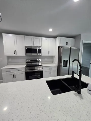 a kitchen with stainless steel appliances a stove a sink and a refrigerator