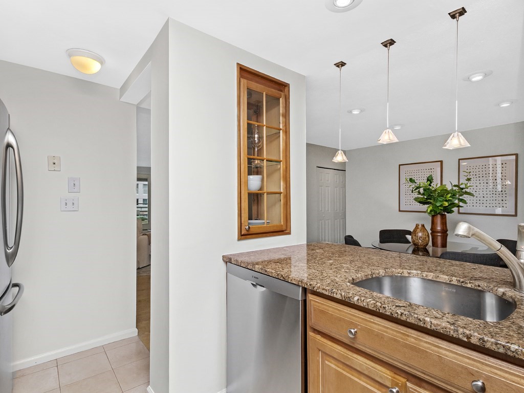 25 Marion Street, Unit PH3 Brookline, MA 02446 - Photo 7 of 22 a kitchen with stainless steel appliances granite countertop a sink a refrigerator and a counter space
