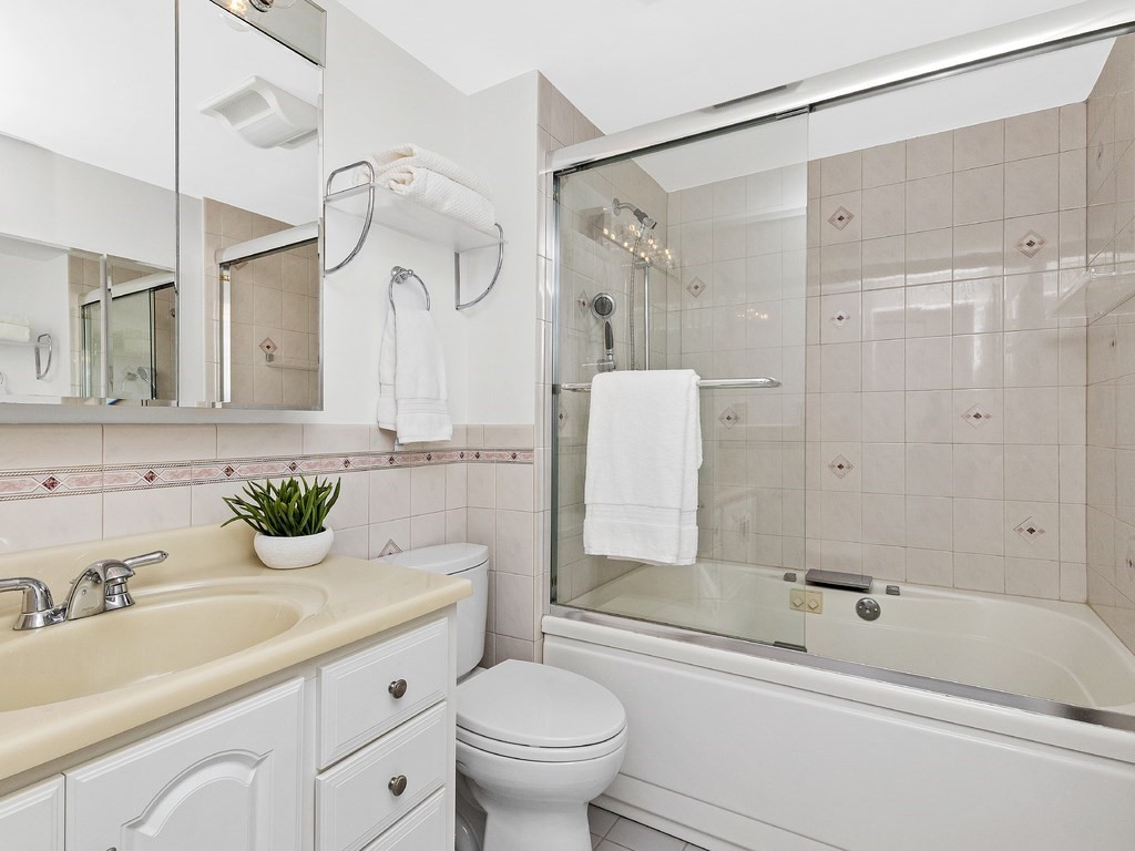 25 Marion Street, Unit PH3 Brookline, MA 02446 - Photo 9 of 22 a bathroom with a tub sink mirror and toilet