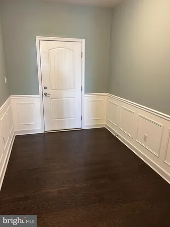 a view of an empty room with wooden floor and cabinet