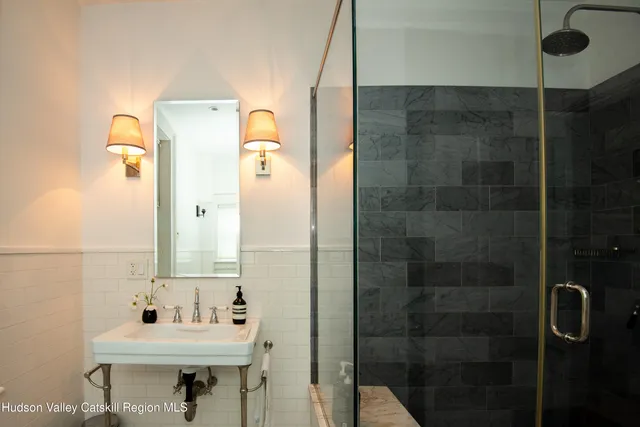a bathroom with a sink mirror toilet and shower