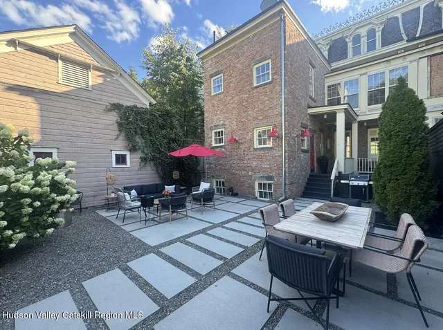 a view of backyard with outdoor seating a patio and plants