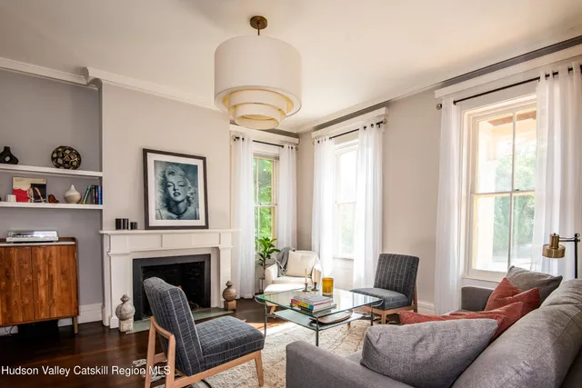 a living room with furniture a fireplace and a large window