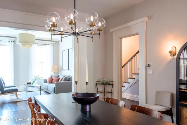 a view of a dining room with furniture a chandelier and wooden floor