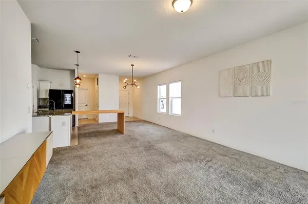 a large white kitchen with cabinets and a refrigerator