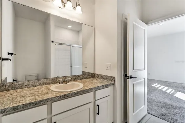 a bathroom with a granite countertop shower mirror and a sink