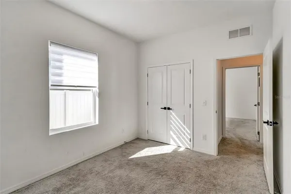 a view of a room with a hallway and closet area
