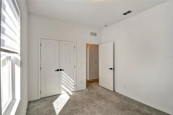 an empty room with windows and closet
