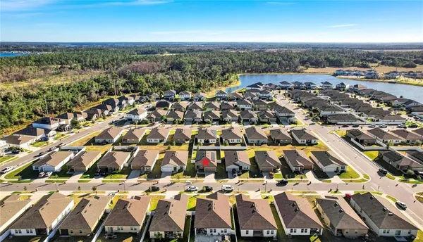 an aerial view of residential houses with outdoor space and ocean view