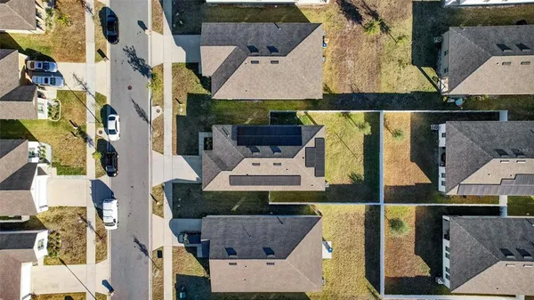 a aerial view of residential houses with large trees and buildings