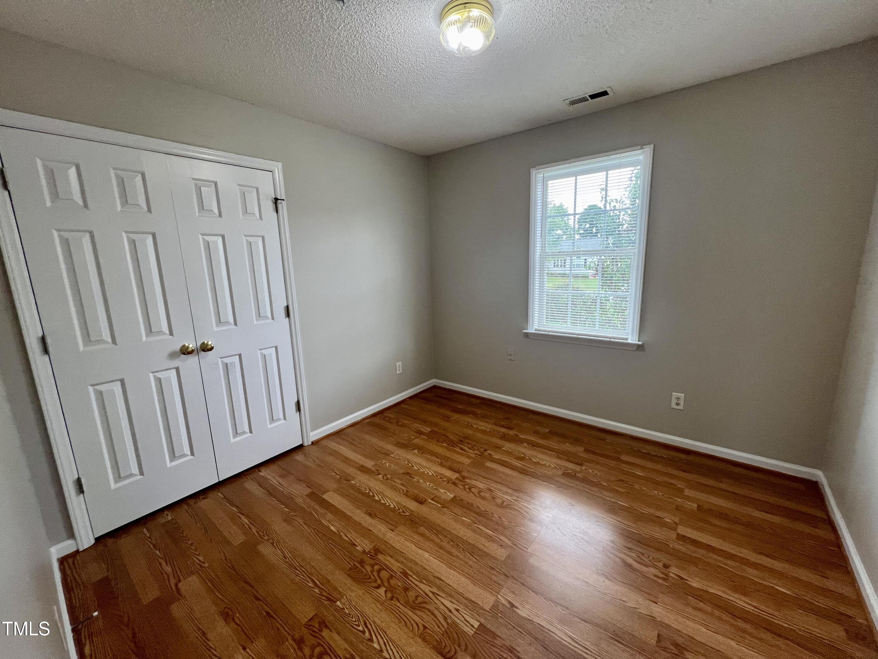 1312 Harvey Johnson Road Raleigh, NC 27603 - Photo 16 of 29 a view of an empty room with wooden floor and a window