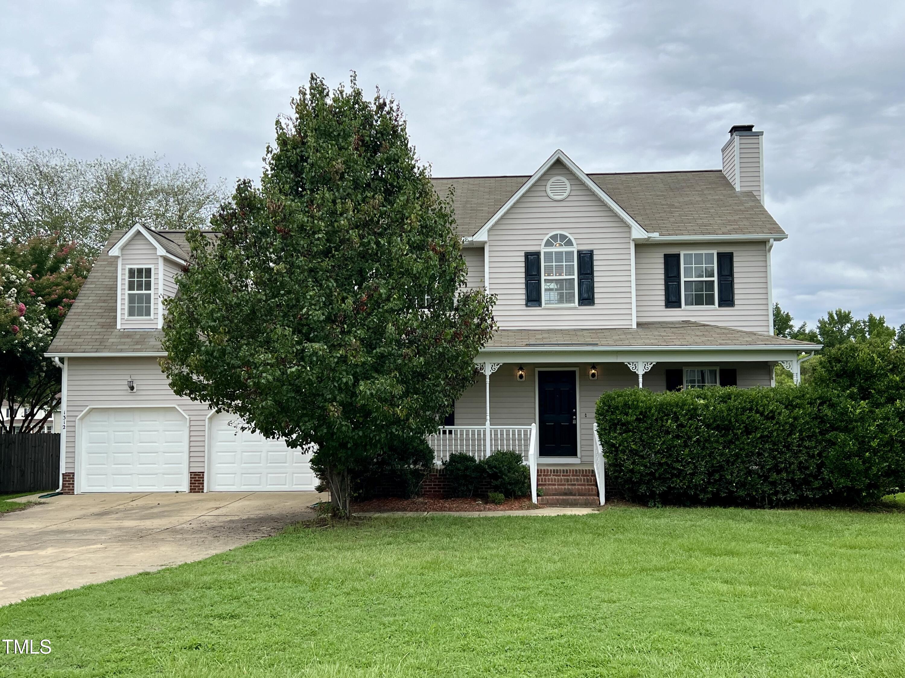 1312 Harvey Johnson Road Raleigh, NC 27603 - Photo 2 of 29 a front view of a house with a yard and garage