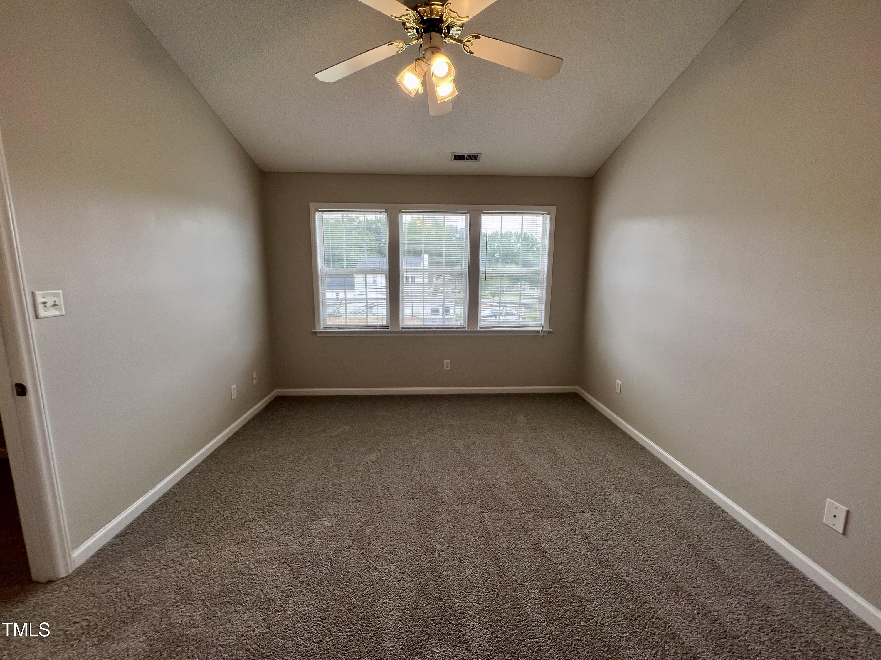 1312 Harvey Johnson Road Raleigh, NC 27603 - Photo 22 of 29 an empty room with chandelier fan and windows