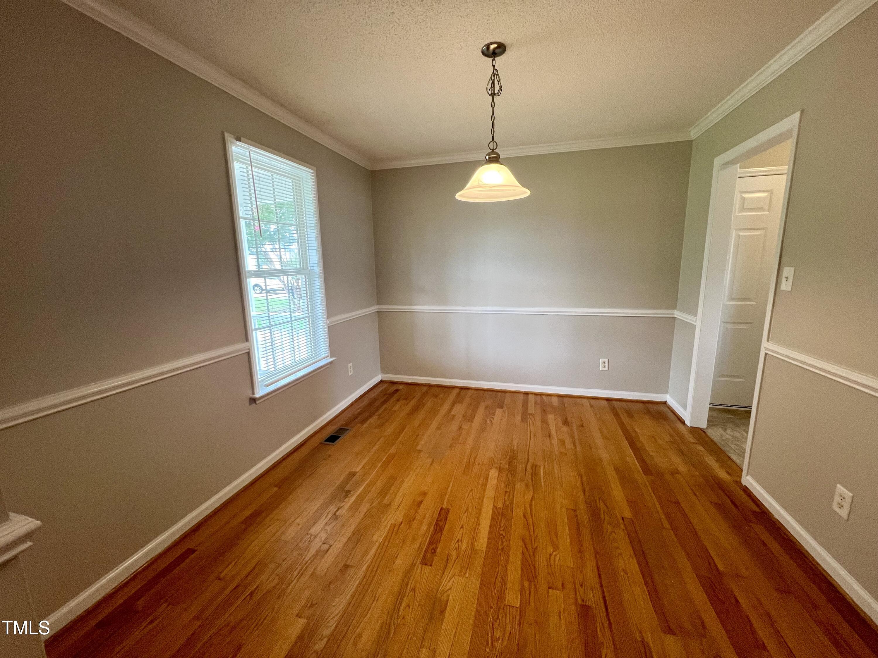 1312 Harvey Johnson Road Raleigh, NC 27603 - Photo 5 of 29 a view of empty room with wooden floor and window