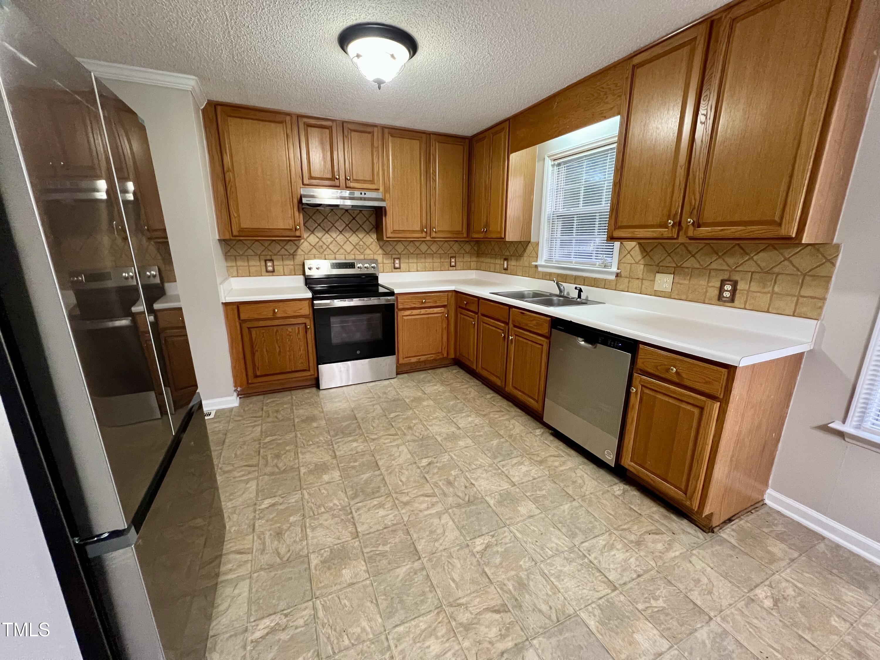 1312 Harvey Johnson Road Raleigh, NC 27603 - Photo 9 of 29 a kitchen with stainless steel appliances granite countertop refrigerator sink and cabinets