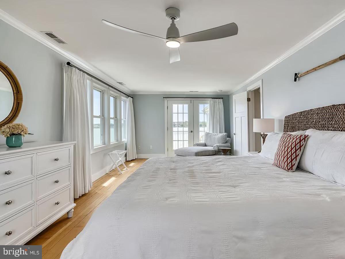 21642 Chicken Point Road Tilghman, MD 21671 - Photo 32 of 63 a spacious bedroom with a large bed and a chandelier fan