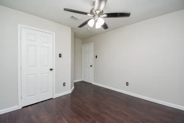 a view of a room with wooden floor and white walls