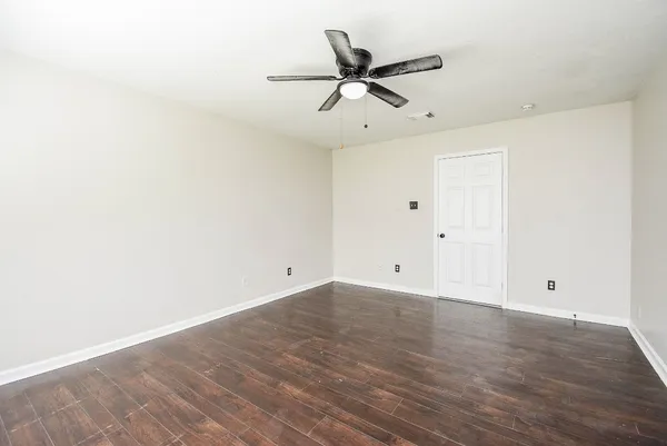 a view of a room with wooden floor and white walls