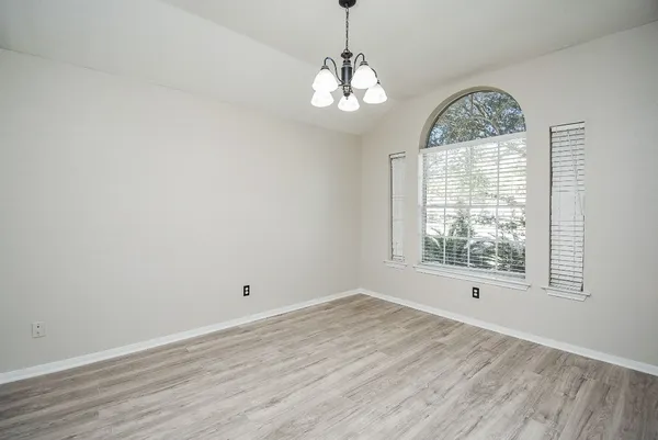 a view of a big room with wooden floor and chandelier