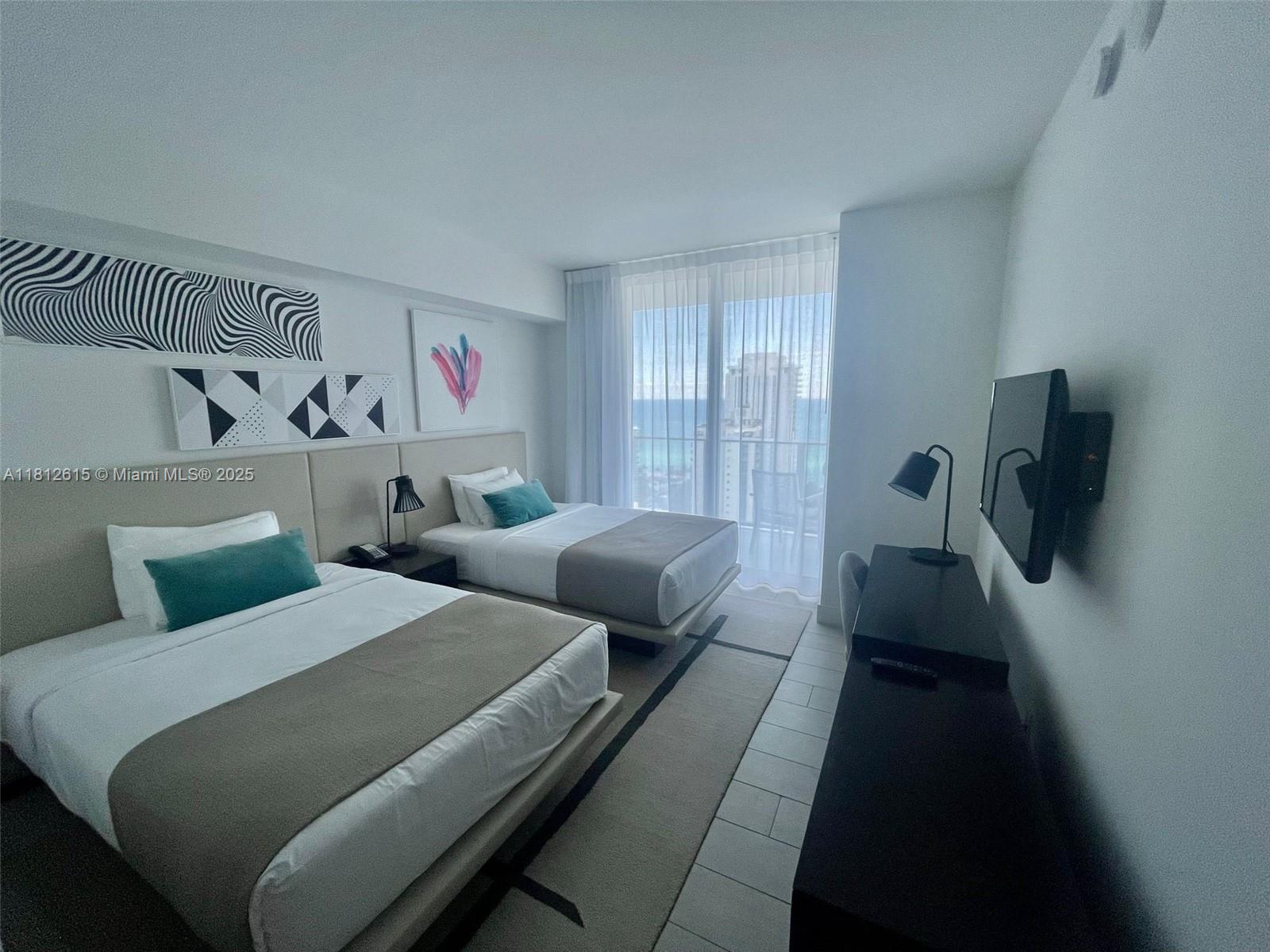 4010 South Ocean Drive, Unit R1705 Hollywood, FL 33019 - Photo 12 of 15 a bedroom with two beds and a window