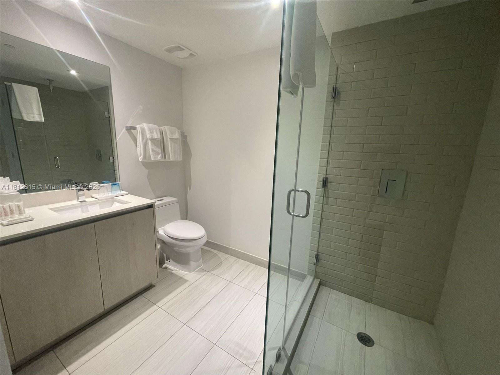 4010 South Ocean Drive, Unit R1705 Hollywood, FL 33019 - Photo 13 of 15 a bathroom with a granite countertop sink a toilet and shower