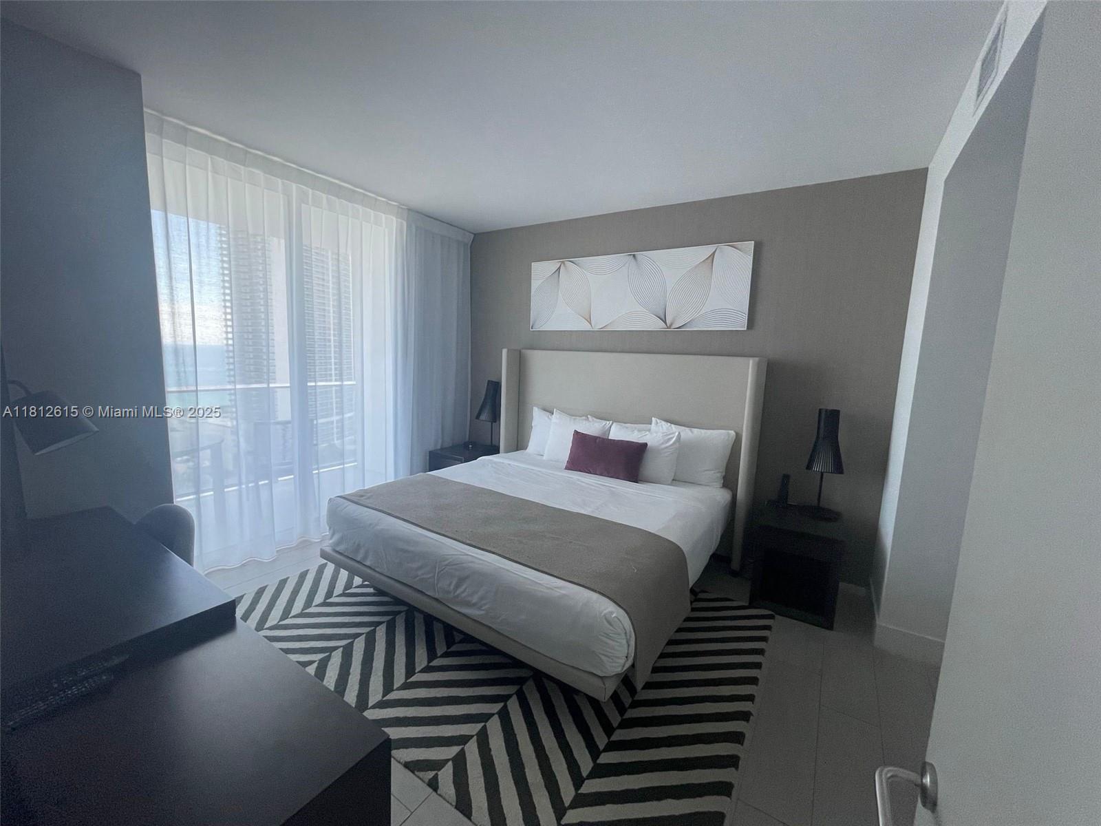 4010 South Ocean Drive, Unit R1705 Hollywood, FL 33019 - Photo 7 of 15 a bedroom with a bed and a table in it