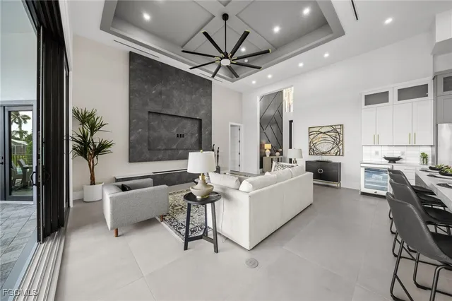a living room with furniture a chandelier and a floor to ceiling window