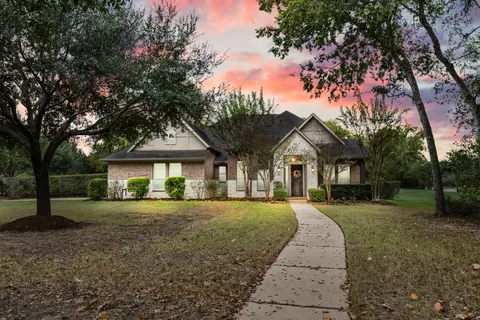 a front view of a house with a yard and trees