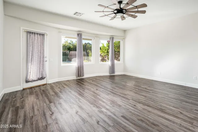 a view of a livingroom with a ceiling fan and window