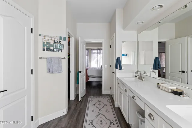 a spacious bathroom with a double vanity sink a mirror and a shower