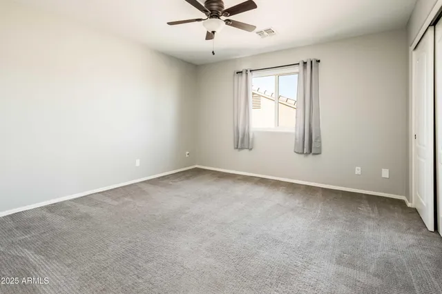an empty room with a window and a ceiling fan
