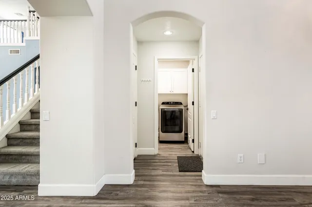 a view of a hallway with wooden floor and staircase