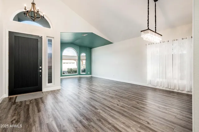 a view of a room with wooden floor ceiling fan and window