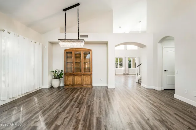 a view of a hallway with wooden floor windows and a living room