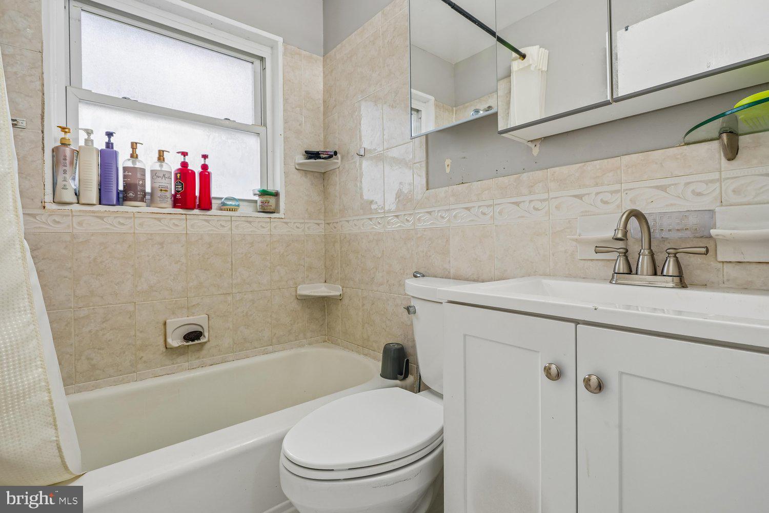 10128 Dallas Avenue Silver Spring, MD 20901 - Photo 17 of 29 a bathroom with a sink a mirror a toilet and bathtub