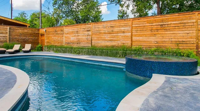 a view of a swimming pool with a chair and tables in the patio