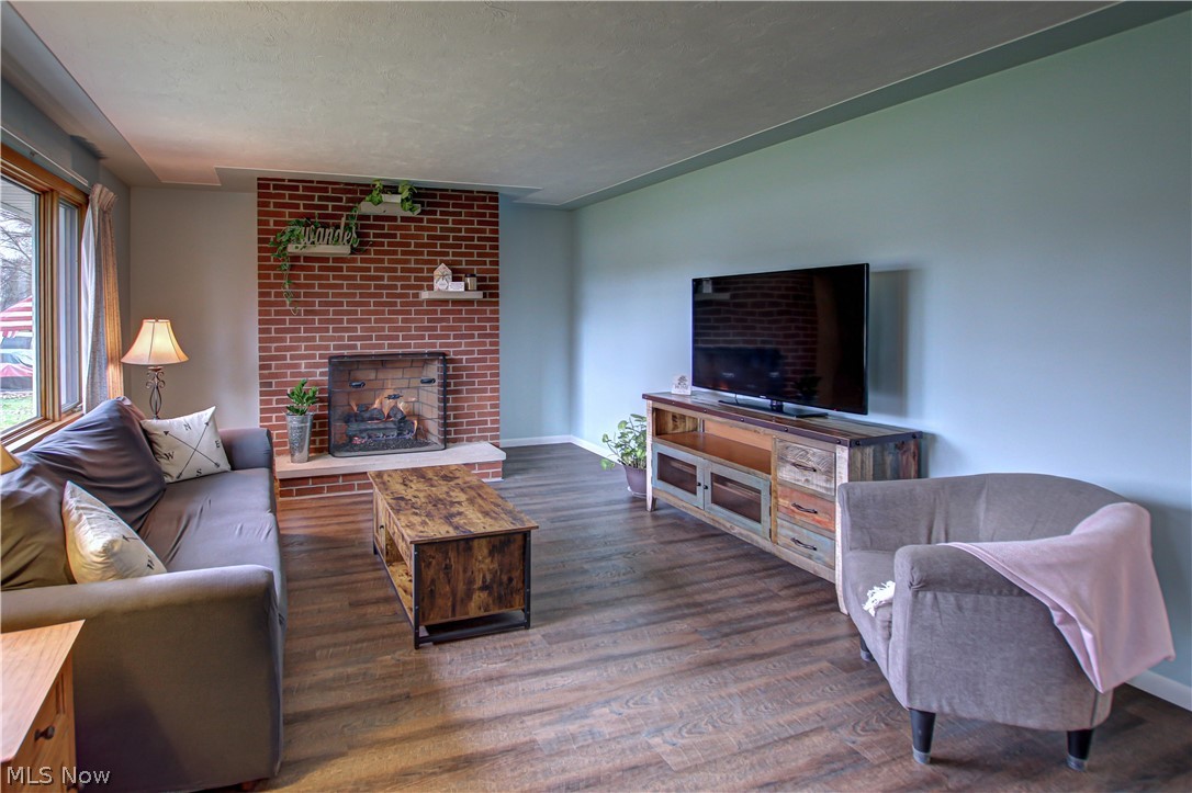 39974 Butternut Ridge Road Elyria, OH 44035 - Photo 12 of 40 Living room with a textured ceiling, a brick fireplace, dark wood-type flooring, and brick wall