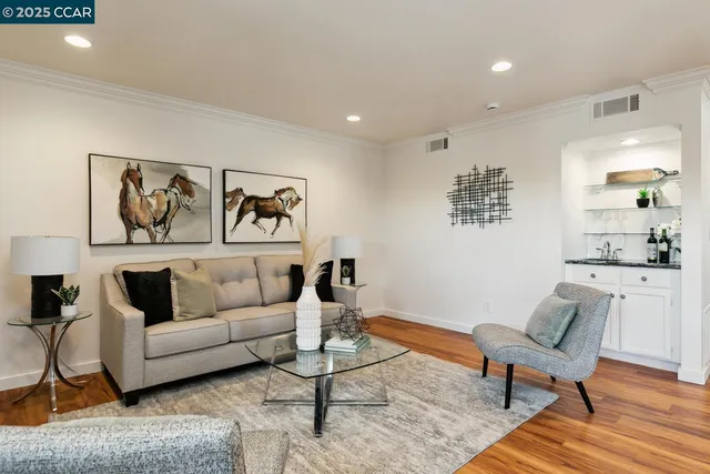 a living room with furniture and a view of kitchen