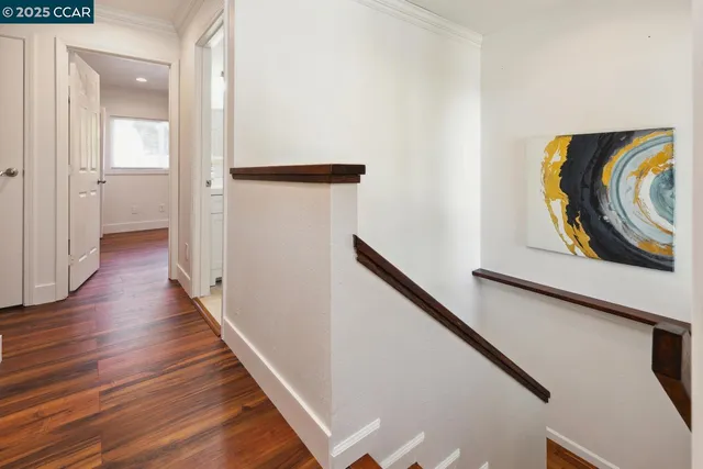 a view of a hallway with wooden floor and stairs