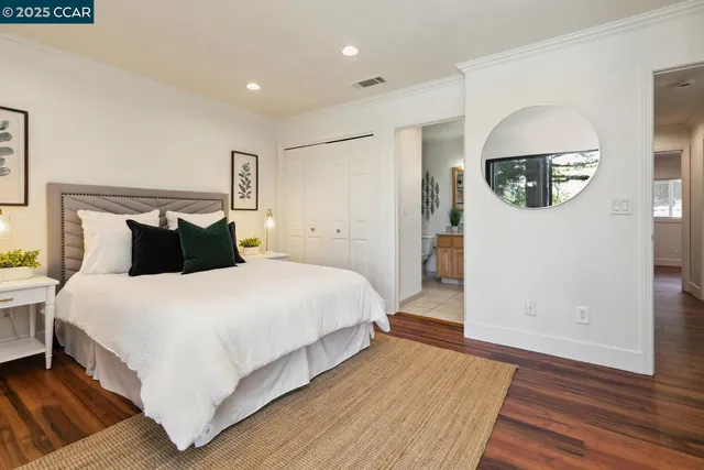 a bedroom with a bed and a painting on the wall