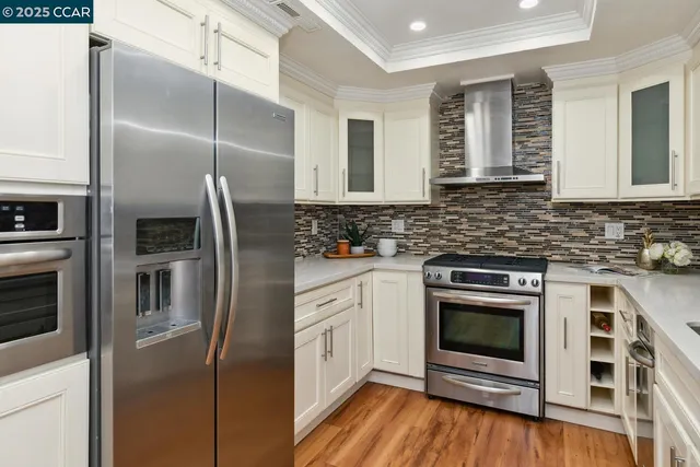 a kitchen with stainless steel appliances granite countertop a stove a refrigerator and a microwave