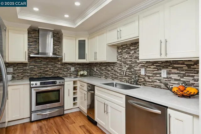 a kitchen with stainless steel appliances granite countertop a sink a stove and cabinets