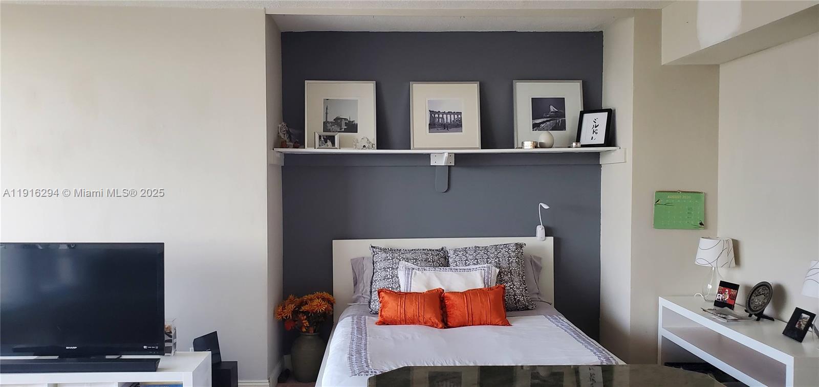 1720 Harrison Street, Unit 10G Hollywood, FL 33020 - Photo 9 of 20 a bedroom with a bed and flat screen tv