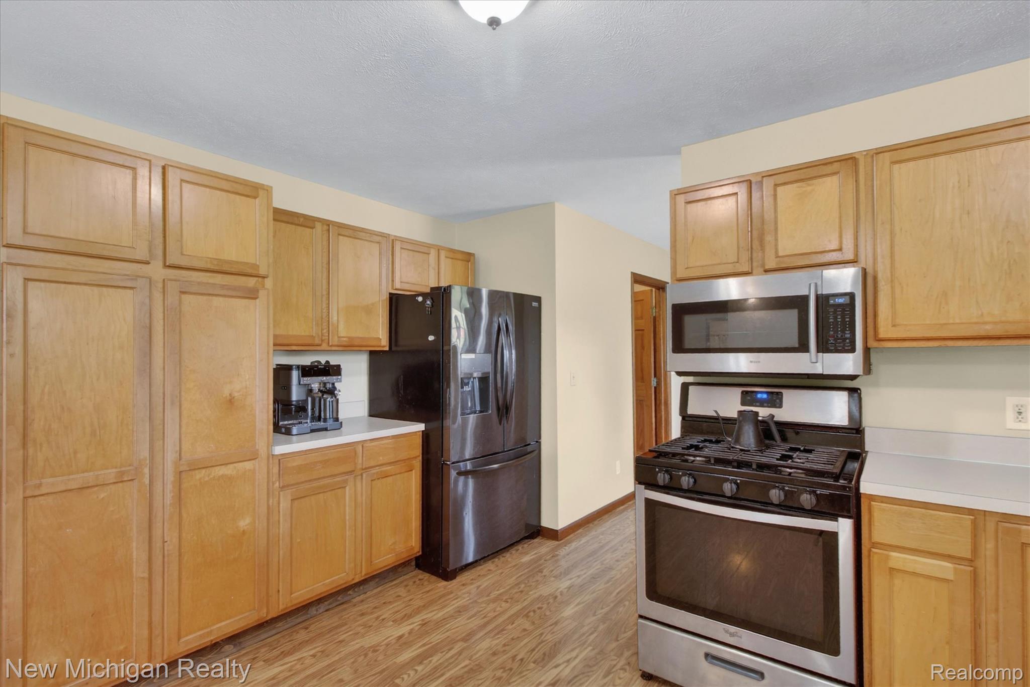 22623 11 Mile Road Reed City, MI 49677 - Photo 18 of 47 Kitchen featuring wood-finish flooring and light wood cabinetry