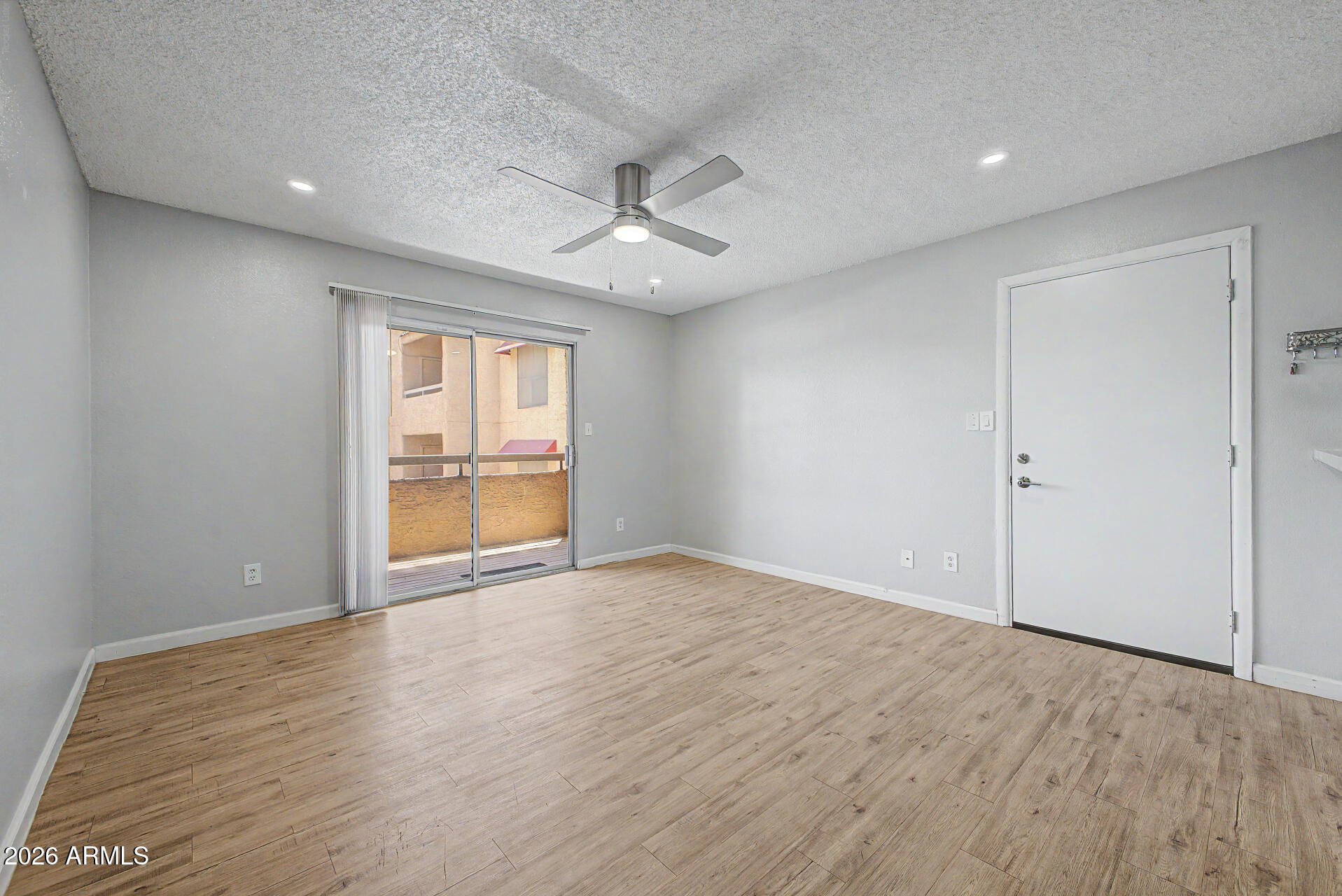 2625 East Indian School Road, Unit 227 Phoenix, AZ 85016 - Photo 8 of 31 an empty room with wooden floor and windows