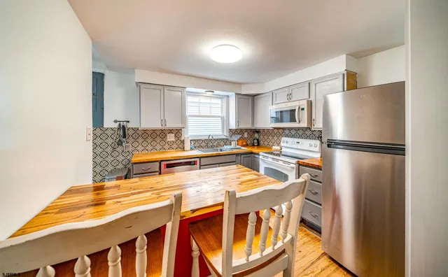 a kitchen with stainless steel appliances granite countertop a refrigerator and a stove