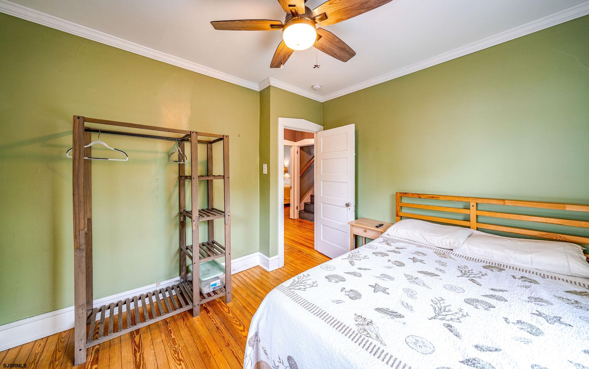 321 Central Avenue Ocean City, NJ 08226 - Photo 20 of 61 a bedroom with a bed and a chandelier