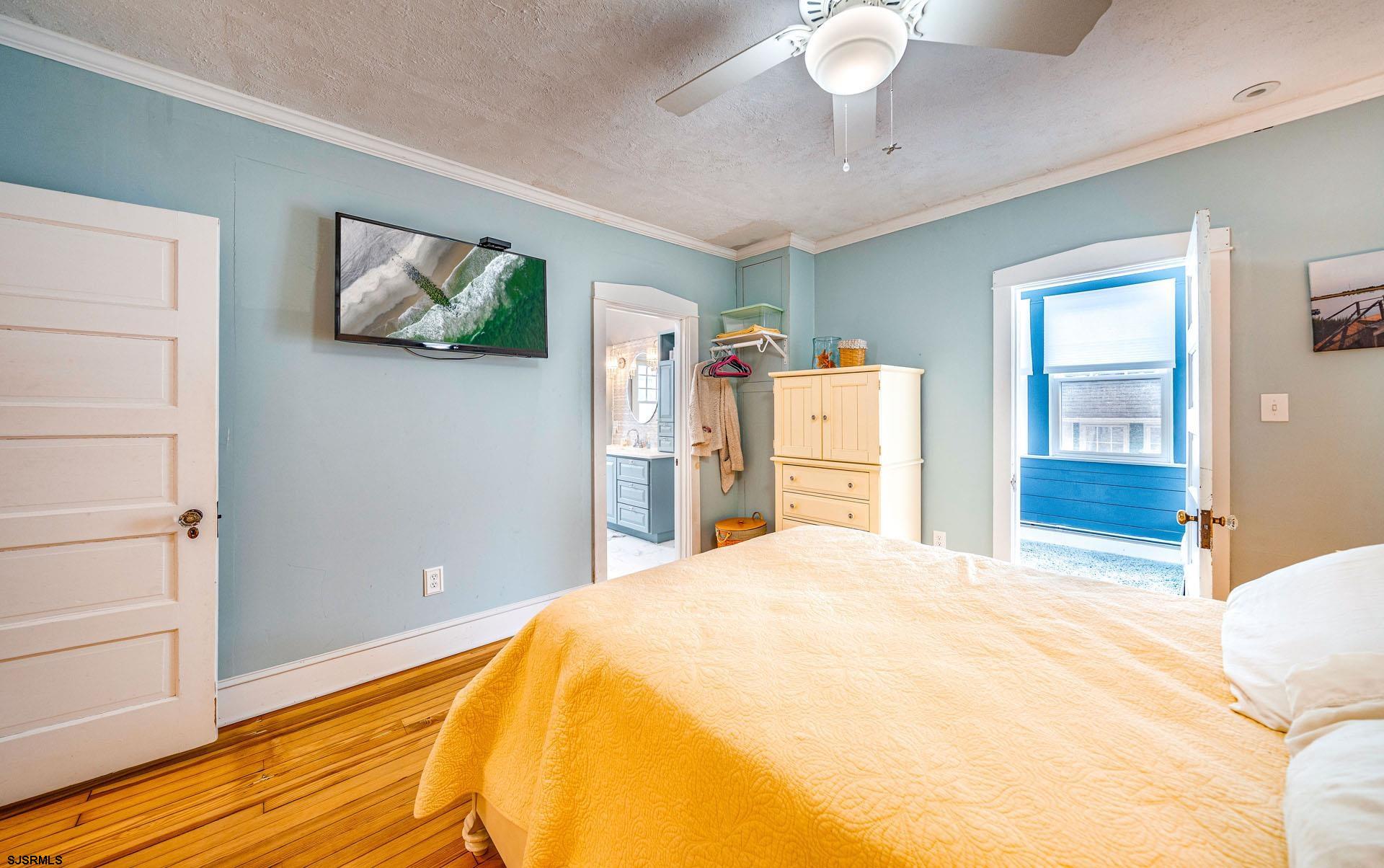 321 Central Avenue Ocean City, NJ 08226 - Photo 25 of 61 a bedroom with a bed and a chandelier