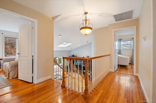 a view of a hallway with wooden floor and staircase
